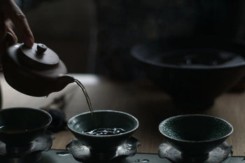 Tea being poured into cups for traditional Pu Erh tea ceremony