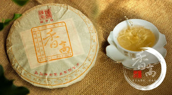 Pancake-shaped Tea with a Cup of Brewed Tea for 2020 ChenShengHao Xiang Gao Raw Pu’er article