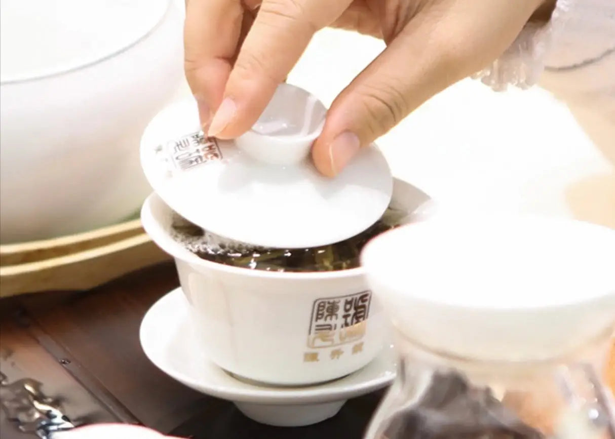 White ceramic tea set for brewing Pu-erh tea on a wooden table