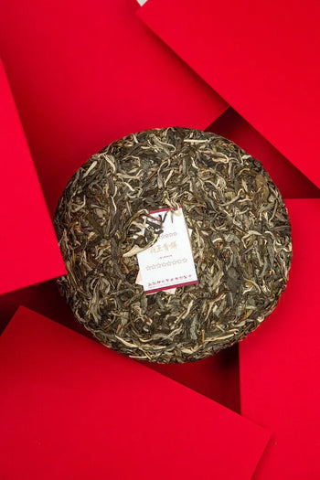 Round compressed Pu Erh tea cake ready for breaking and rinsing in tea preparation