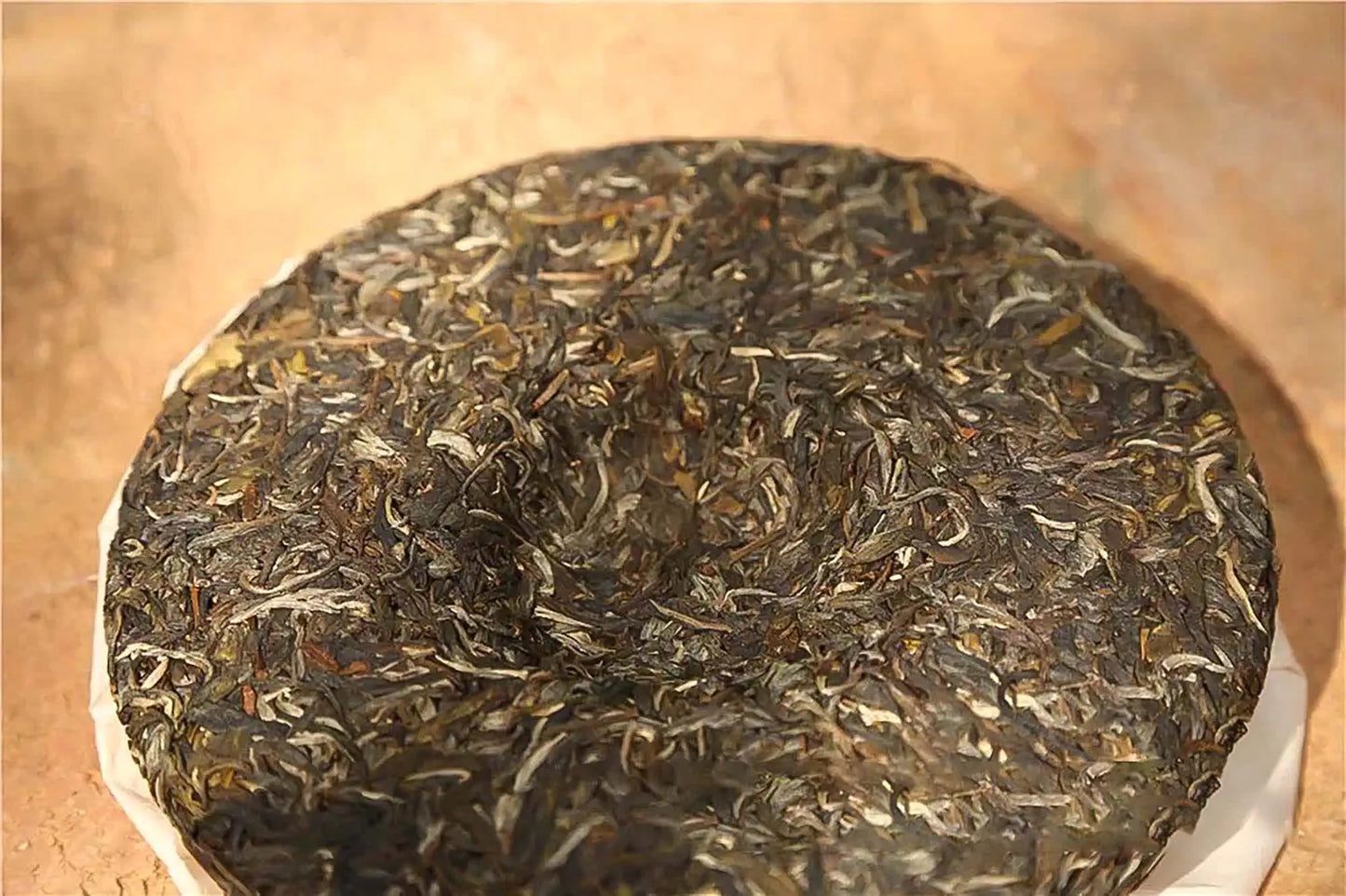 Compressed tea leaves forming a small nest on a Pu-erh tea cake