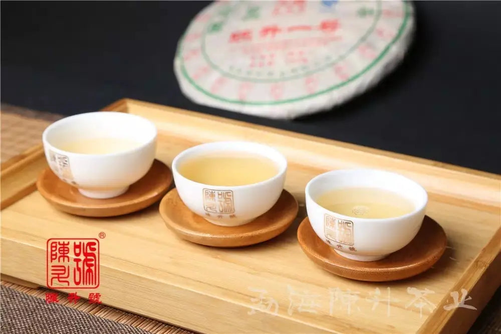 Three white teacups filled with tea featured in an article about caffeine in Pu Erh Tea