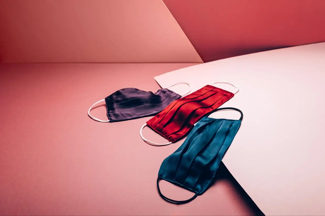 Three colorful silk face masks displayed for fighting acne through skincare
