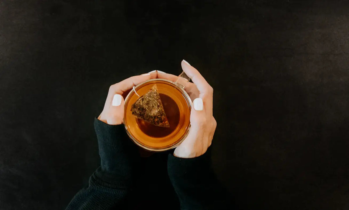 Hands holding a tea cup showcasing the perfect way to enjoy your favorite Teabags