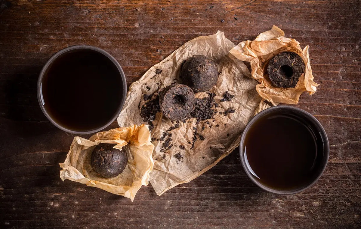 Dark Pu Erh tea cakes and cups displayed for promoting skin health benefits