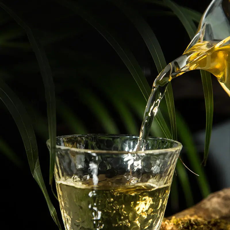 Golden liquid pouring into textured glass for steeping tea article