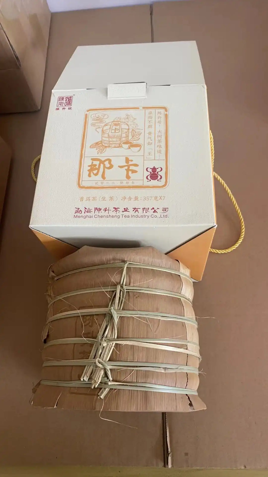 A Na Ka tong of seven bamboo-wrapped cakes beside its gift box
