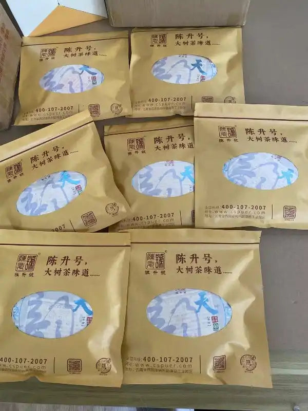 Multiple sealed gold-colored pouches of tea.