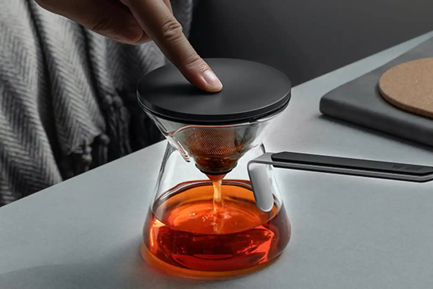 A white ceramic teacup filled with dark amber tea.